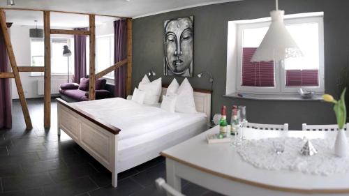 a bedroom with a bed and a desk in it at Pension & Seminarhaus "Haus am Fluss" in Laurenburg