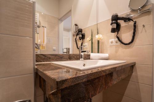 a bathroom with a sink and a phone on the wall at Hotel St Georg - Regensburg in Regensburg