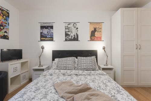ein Schlafzimmer mit einem Bett, einem Fernseher und Postern in der Unterkunft San Lio Romantic X2 a Rialto in Venedig