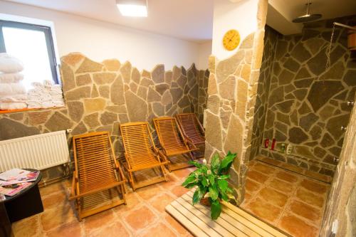 een groep stoelen in een kamer met een stenen muur bij Horský Hotel Dobrá Chata in Stachy
