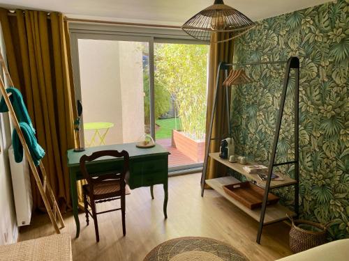 a room with a desk and a chair and a window at Chambre Cocoon dans une maison avec SPA et jardin en centre ville in Dijon