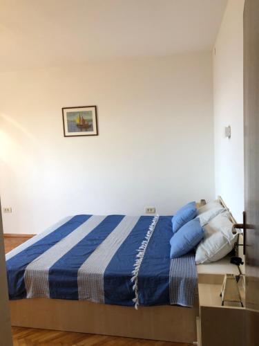 a bedroom with a bed with blue and white sheets at Apartment Bella Costa in Rijeka