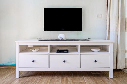 a white entertainment center with a flat screen tv on top at A due passi da mare in Abbiadori