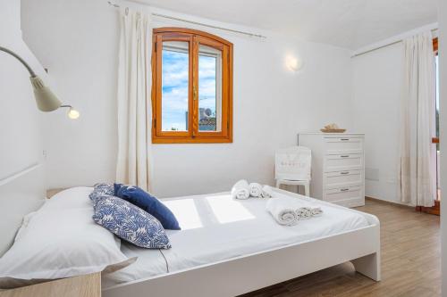A due passi da mare في Abbiadori: غرفة نوم بيضاء بها سرير ونافذة