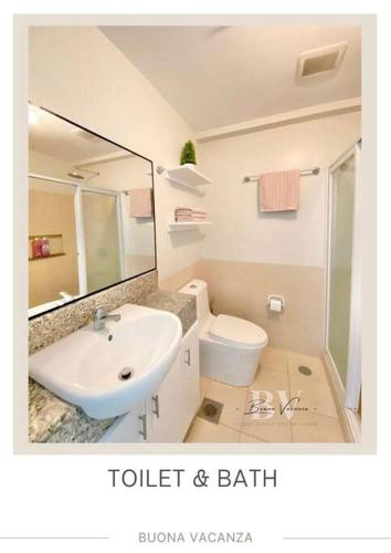 een badkamer met een wastafel, een toilet en een spiegel bij Buona Vacanza at Verdon Parc in Davao City