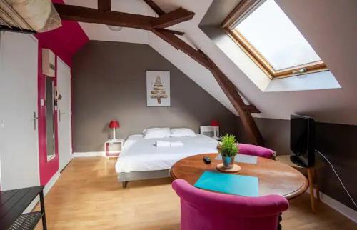 a bedroom with a bed and a table and chairs at Point calme & stratégique de Tours in Tours