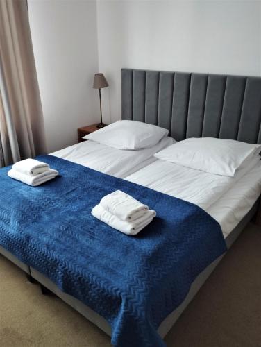 two white towels sitting on top of a bed at Hotel Boruta in Zakopane