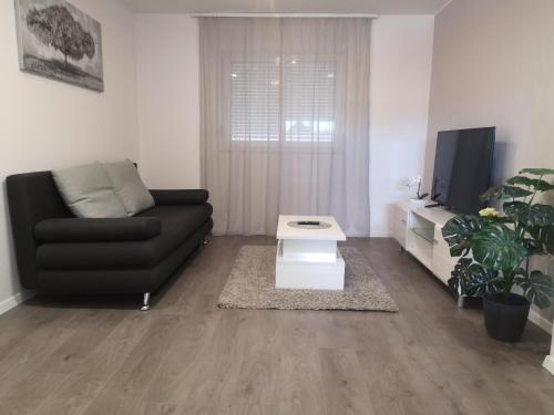 un soggiorno con un divano nero e una TV di Apartment Mateo a Spalato (Split)