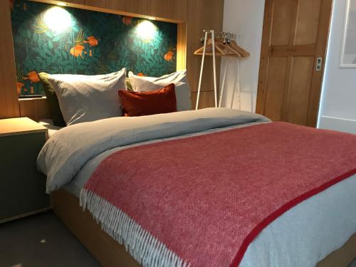 ein Schlafzimmer mit einem großen Bett mit einer roten Decke in der Unterkunft Sommarhus in Zandvoort