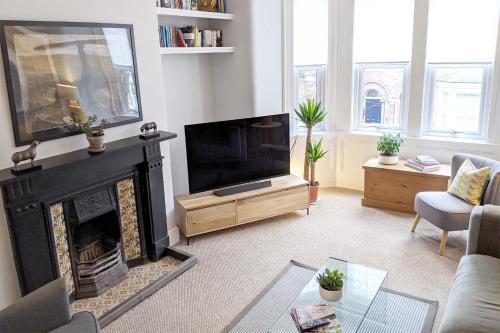 a living room with a fireplace and a television at Townhouse Apartment Carlisle in Carlisle