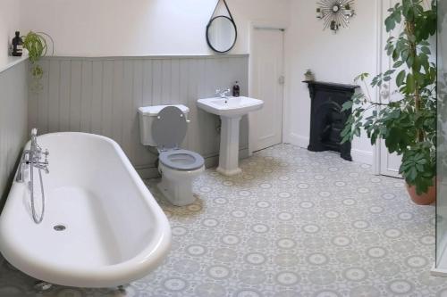 a bathroom with a tub and a toilet and a sink at Townhouse Apartment Carlisle in Carlisle