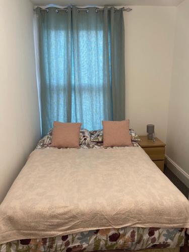 a bedroom with a large bed with blue curtains at private room 6 in Bristol