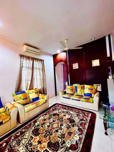ein Wohnzimmer mit 2 Sofas und einem Teppich in der Unterkunft Riffain Villa Homes in Alor Setar