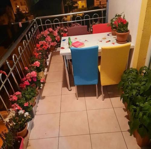 a table with colorful chairs and flowers on a balcony at MY HOME in Beysehir