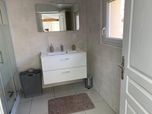 bagno con lavandino bianco e specchio di Maison de 1 a 8 personnes entièrement rénovée a Charly-sur-Marne