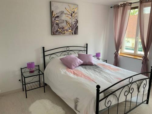 una camera da letto con un letto con cuscini viola di Maison de 1 a 8 personnes entièrement rénovée a Charly-sur-Marne