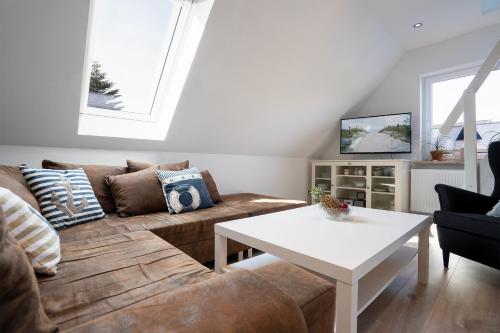 a living room with a couch and a table at Haus Strandwinkel Ferienwohnung "Strandwinkel 1" in Scharbeutz