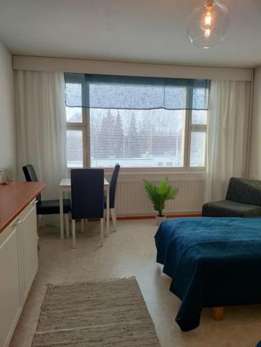 een slaapkamer met een bed, een tafel en een bureau bij Toimiva kodikas yksiö in Heinola
