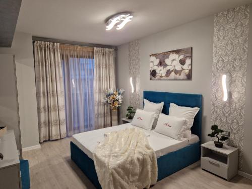 a bedroom with a blue and white bed and a window at Alecsa 2 Luxury Residence in Mamaia