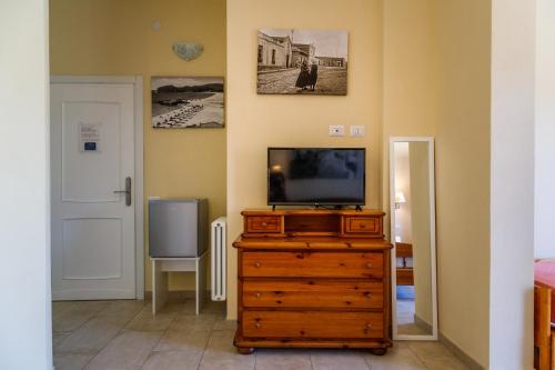 a living room with a television on a dresser at Casa Tacconi in Villasimius