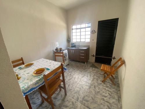 Habitación con mesa y cocina con fregadero en Apartamento Inteiro Central 2 Quartos e Kitnet Inteira 01 quarto, en Ponta Grossa