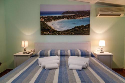 a bedroom with a bed with two white pillows at Casa Tacconi in Villasimius
