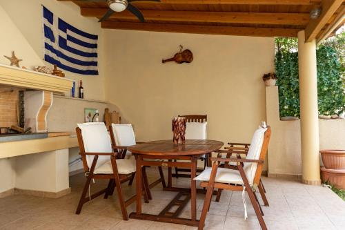 a dining room with a wooden table and chairs at Bolero Apartment Argostoli in Argostoli