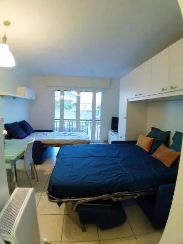 a bedroom with a large blue bed and a table at Gabriella in Menton
