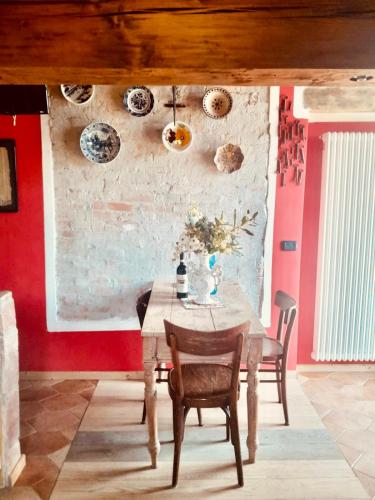 a dining room with a table and a red wall at Casa Unica- da Bruno in Colico