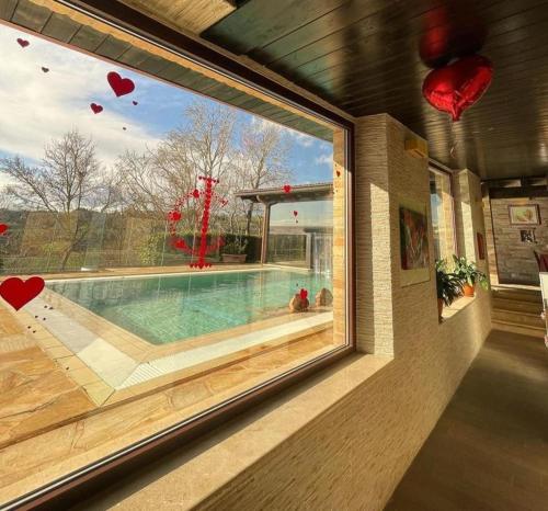 a window of a house with a swimming pool at Colle Indaco Wine Resort & Spa in Ortezzano