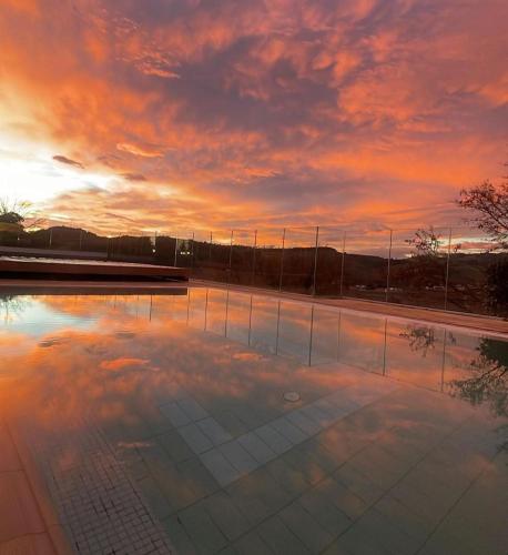 an empty pool with a sunset in the background at Colle Indaco Wine Resort & Spa in Ortezzano