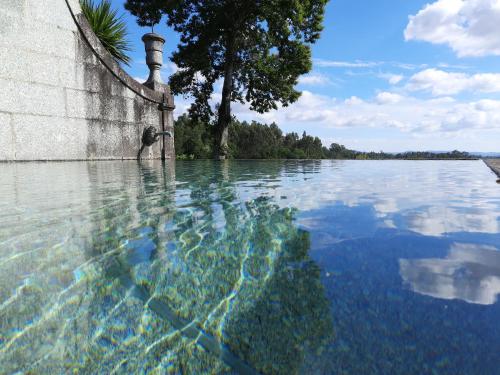 a pool of water next to a wall at Cazal Da Lamella in Fafe