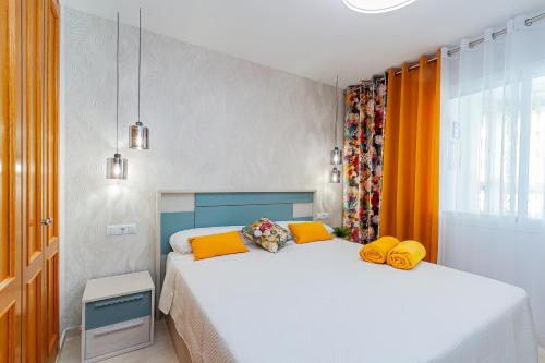 Espanatour BENIMAR في كالا دي فينيسترات: غرفة نوم بسريرين مع وسائد صفراء
