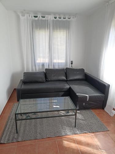 a black couch in a living room with a glass table at Casa Santa Elena in Santa Cristina d'Aro
