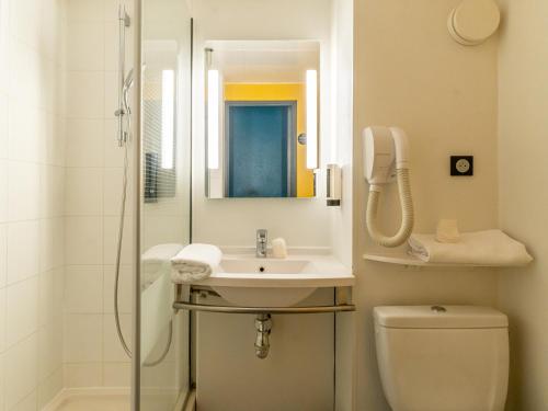 La salle de bains est pourvue d'une douche, d'un lavabo et de toilettes. dans l'établissement B&B HOTEL Marseille Prado Parc des Expositions, à Marseille