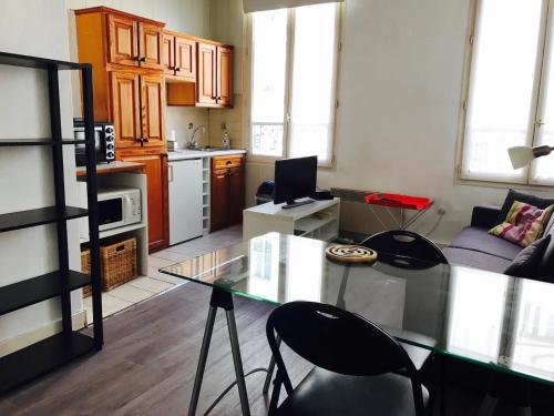 une cuisine avec une table en verre et des chaises dans une pièce dans l'établissement Studio Oberkampf, à Paris