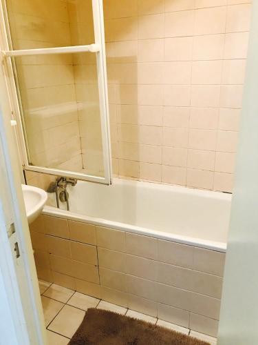 une salle de bain avec une baignoire et un lavabo dans l'établissement Studio Oberkampf, à Paris