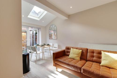 a living room with a brown couch and a table at Beautiful, 3 Bedroom Terrace, 2 minutes walk from Chester train station. in Chester