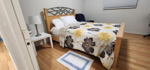 a bedroom with a bed with a floral comforter at ChessKings Executive Suite - 2 Bedrooms in Winnipeg