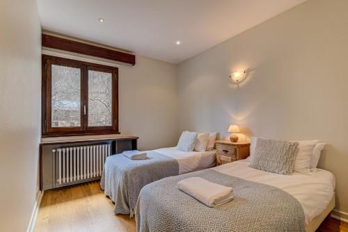 une chambre avec deux lits et une fenêtre dans l'établissement APARTMENT PRESIDENT - Alpes Travel - Central Chamonix - Sleeps 12, à Chamonix-Mont-Blanc