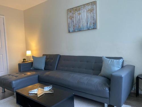 a living room with a blue couch and a table at AA Chester in Chester-le-Street