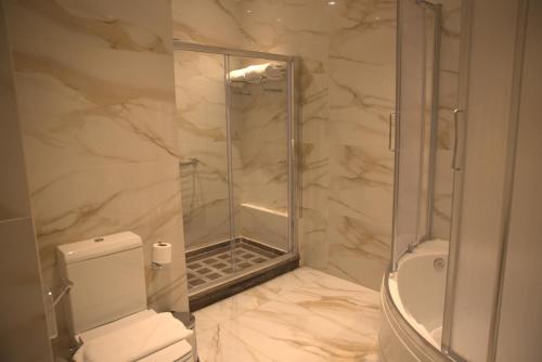 a bathroom with a shower and a toilet at Helnan Mamoura Hotel & Events Center in Alexandria