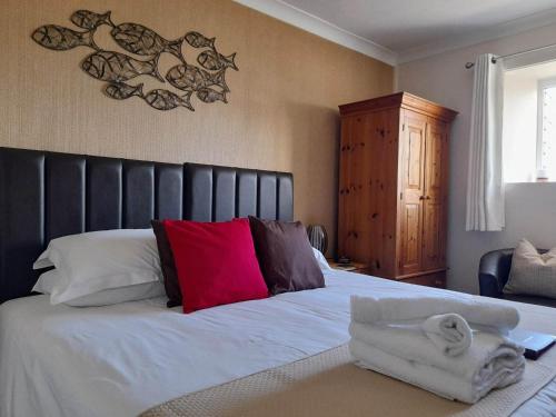 a bedroom with a bed with two towels on it at Thurlestone House in St Ives