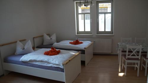 Dos camas en una habitación con animales de peluche rojos. en Ferienwohnung Haus Maria en Mühlhausen
