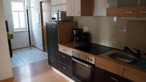 a kitchen with a sink and a stove top oven at Ferienwohnung Haus Maria in Mühlhausen