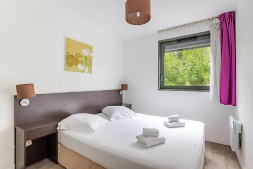 a bedroom with two beds and a window at All Suites Appart Hôtel - Bordeaux Lac in Bordeaux