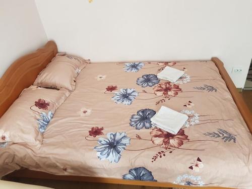 ein Bett mit einer Blumenbettdecke darauf in der Unterkunft Garsoniera Emilia in Câmpulung Moldovenesc