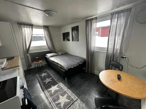 a small living room with a bed and a table at Apartment with shared bathroom in central Kiruna 1 in Kiruna
