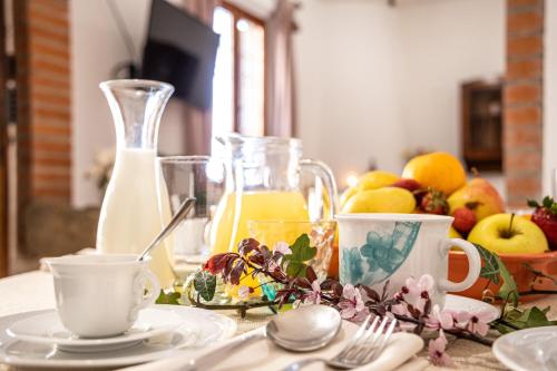a table with a plate of fruit and a jug of orange juice at Agri Apartment La Terrazza La Ripadoro in Chianni