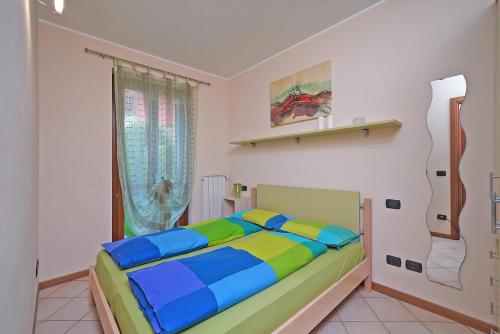 ein Schlafzimmer mit einem farbenfrohen Bett in einem Zimmer in der Unterkunft Messaga in Toscolano-Maderno